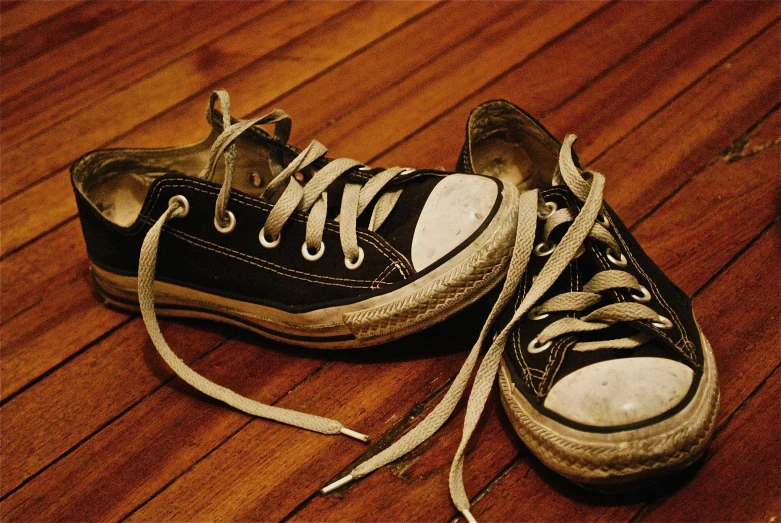 black and white tennis shoes on a wood floor