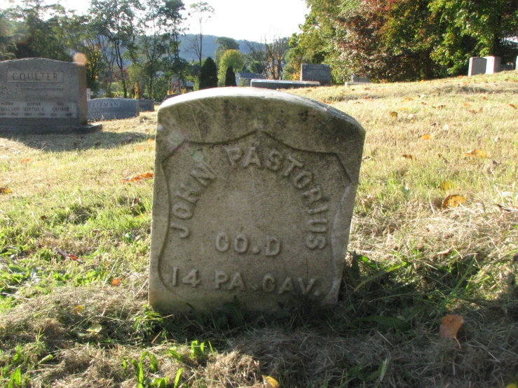a headstone in a cemetery on the ground
