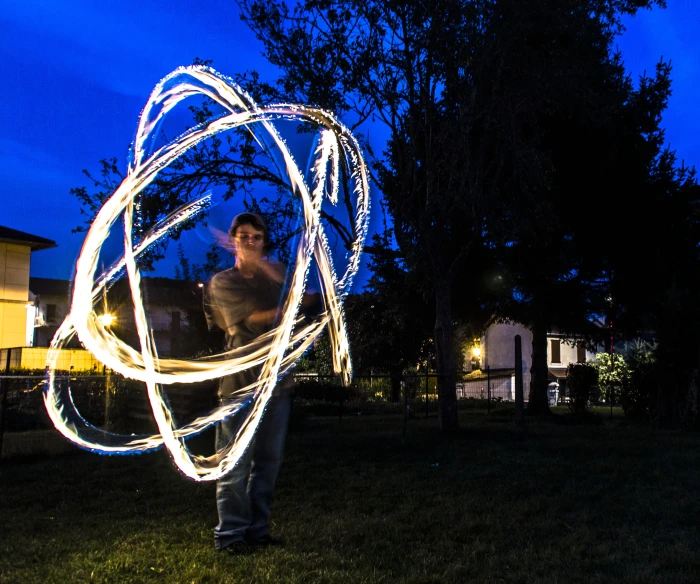 someone is holding an abstract light sculpture in their hands