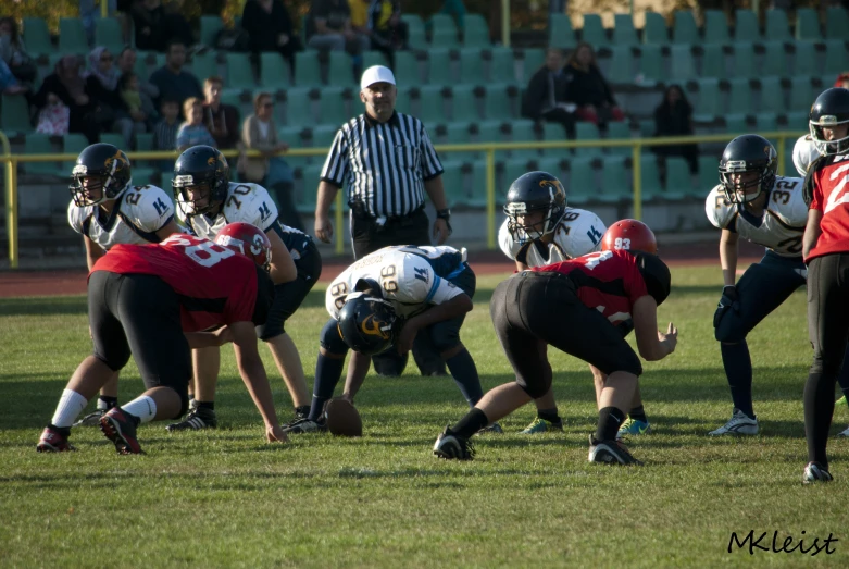 football players in red uniforms and black helmets playing on grass