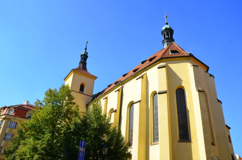 a large yellow building with two towers and clocks