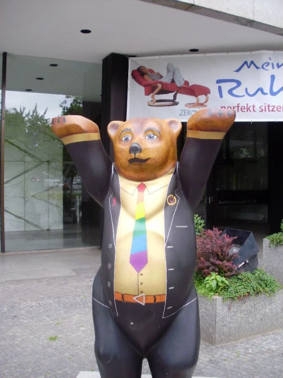 a brown bear statue with a yellow tie