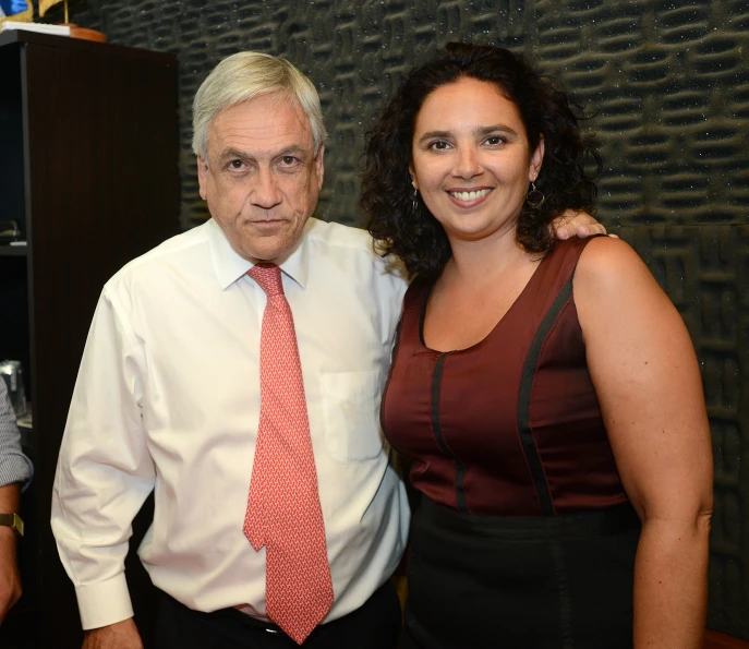 the woman in a maroon dress is standing next to an older man