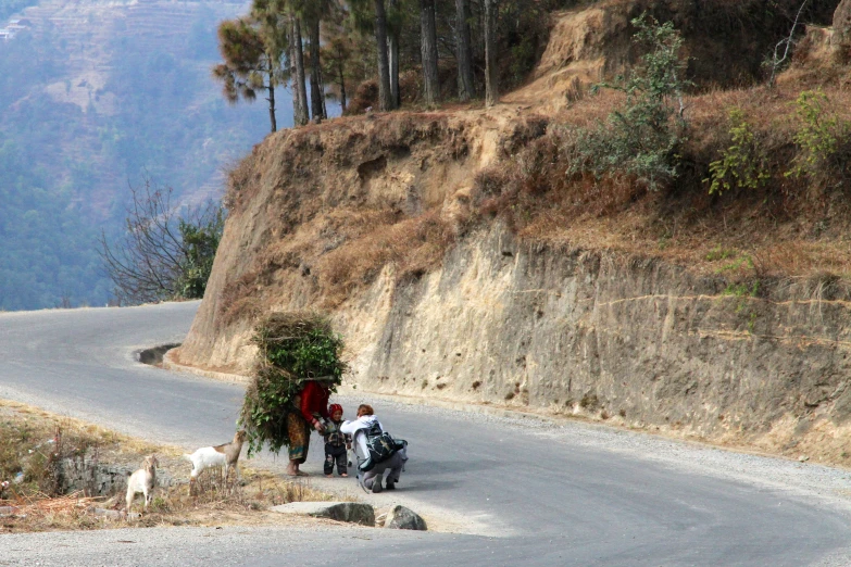 some people are hing their bicycle on the side of a road