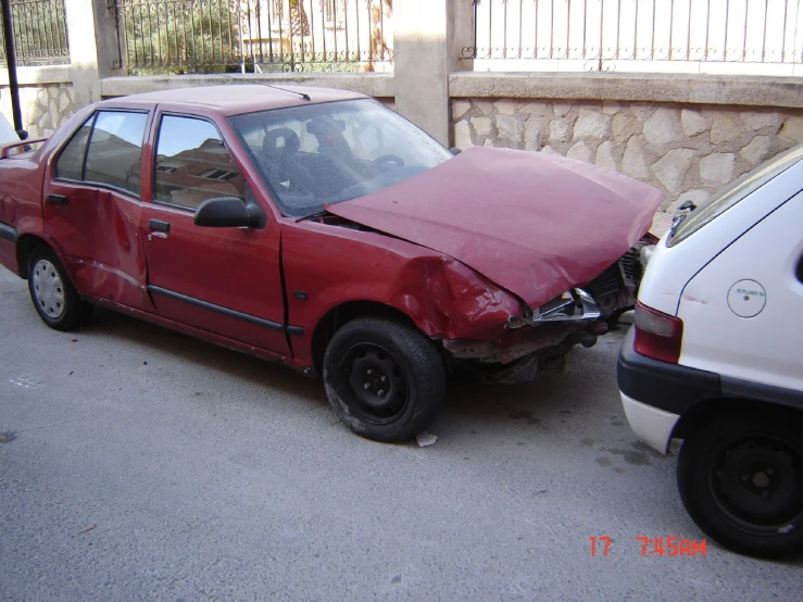 the front of a red car parked on the side of the street