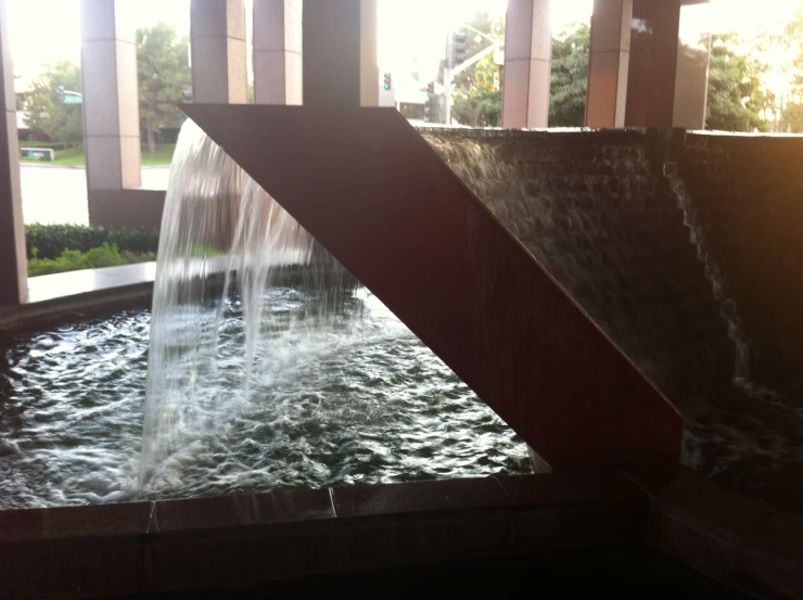 the water spews into the small pond at a public plaza