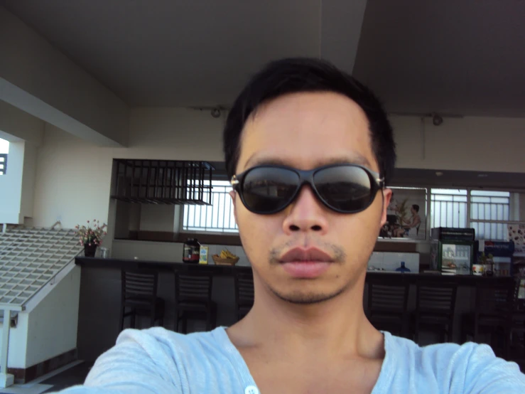 an asian man in sunglasses poses for a po