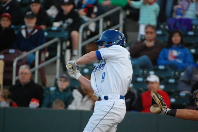 a professional baseball player is swinging at the pitch