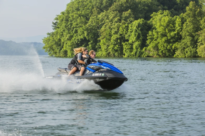 two people on jet skis are moving across the water