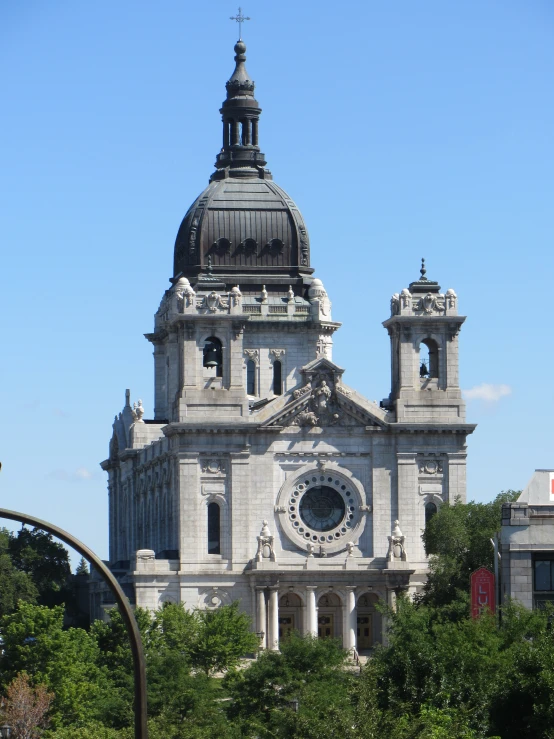 a large gray church with tall spires surrounded by trees