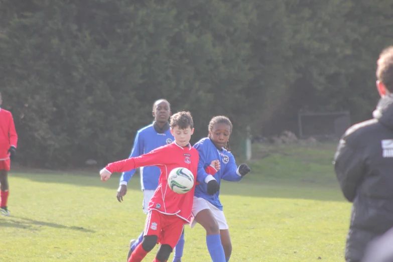 some young men playing soccer together on a grass field