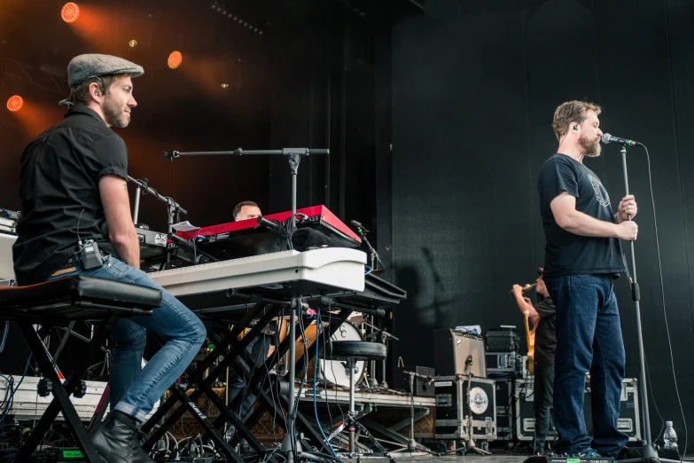 some men sitting and singing on stage