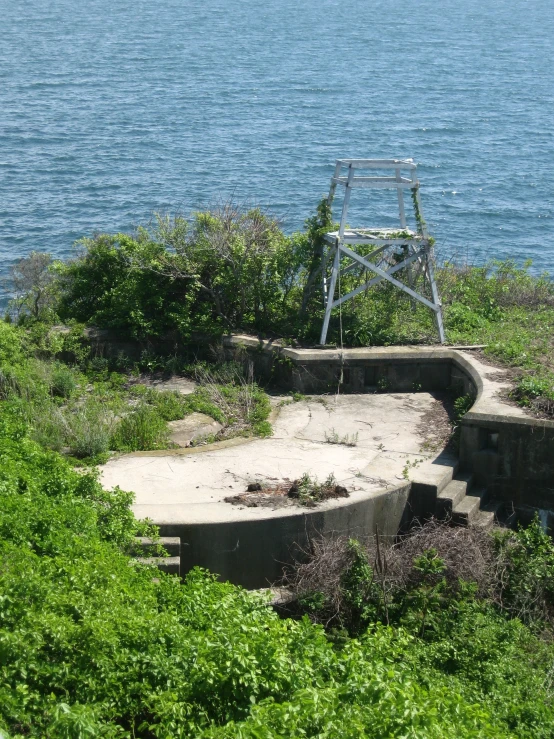 a bench is seen in the foreground, looking over the water