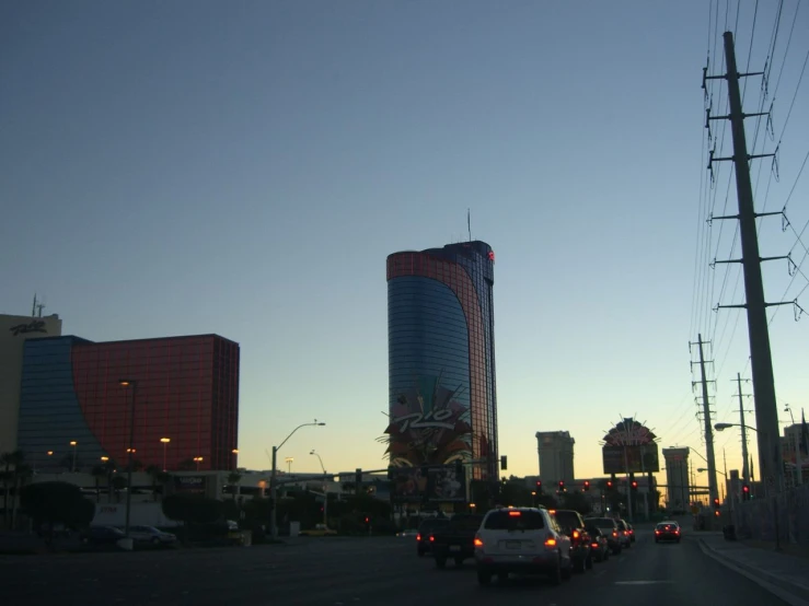 a bunch of cars traveling down the road at sunset