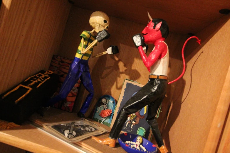 a couple of figurines sitting on top of a shelf