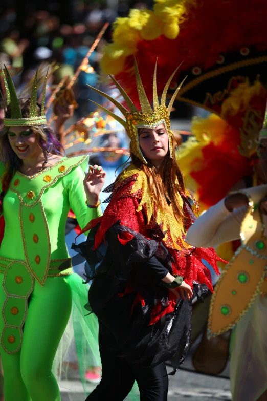 several young people in colorful costumes dancing at a parade