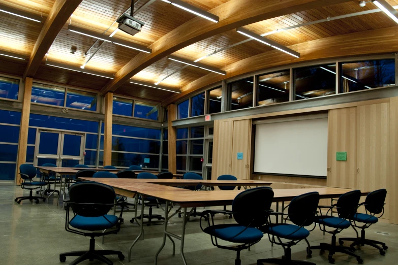 a conference room with blue chairs and a large projector screen