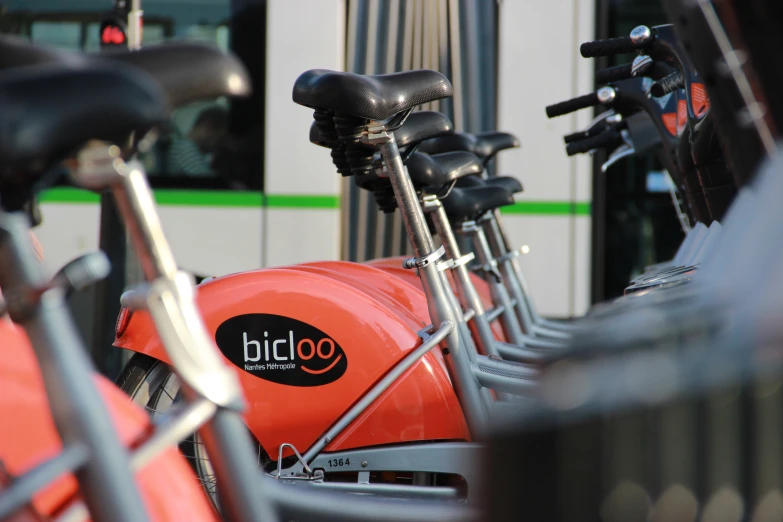 row of red bikes sitting next to each other outside