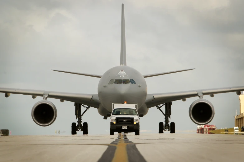 the vehicle is towing a large white plane