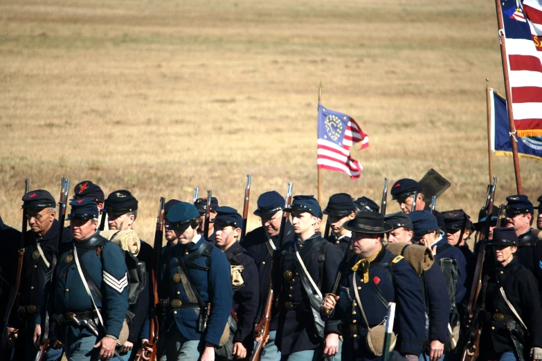 a group of men in uniform standing near flags