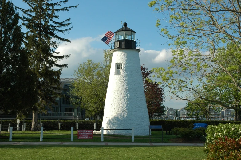 a white light house on a green lawn