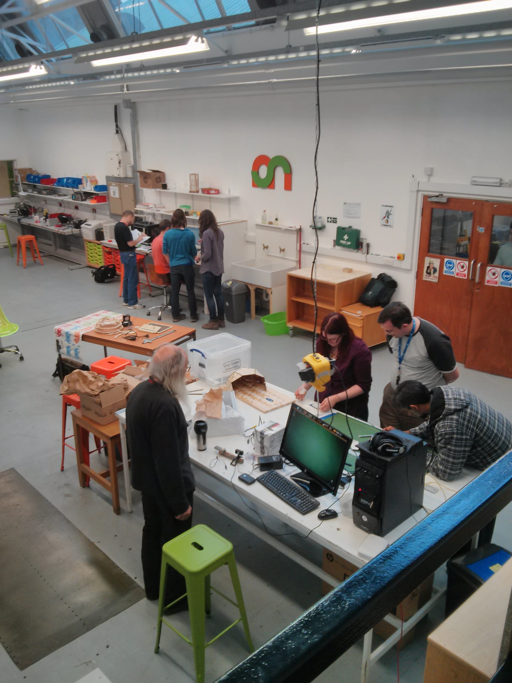 an open workshop with many people working on various desks