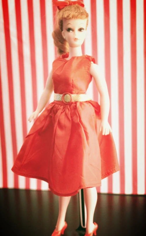 the doll is wearing a bright red dress