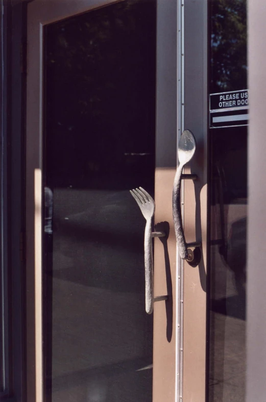 a fork and knife hanging out the side of a door