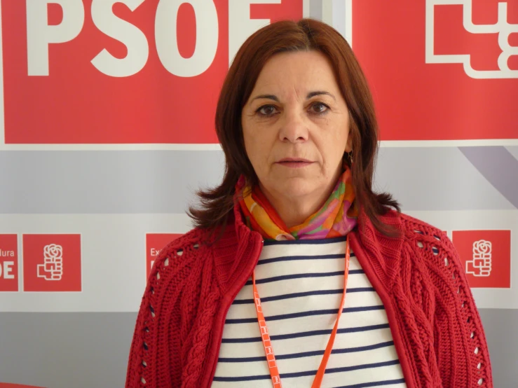 a woman in red and white sweater standing next to a banner