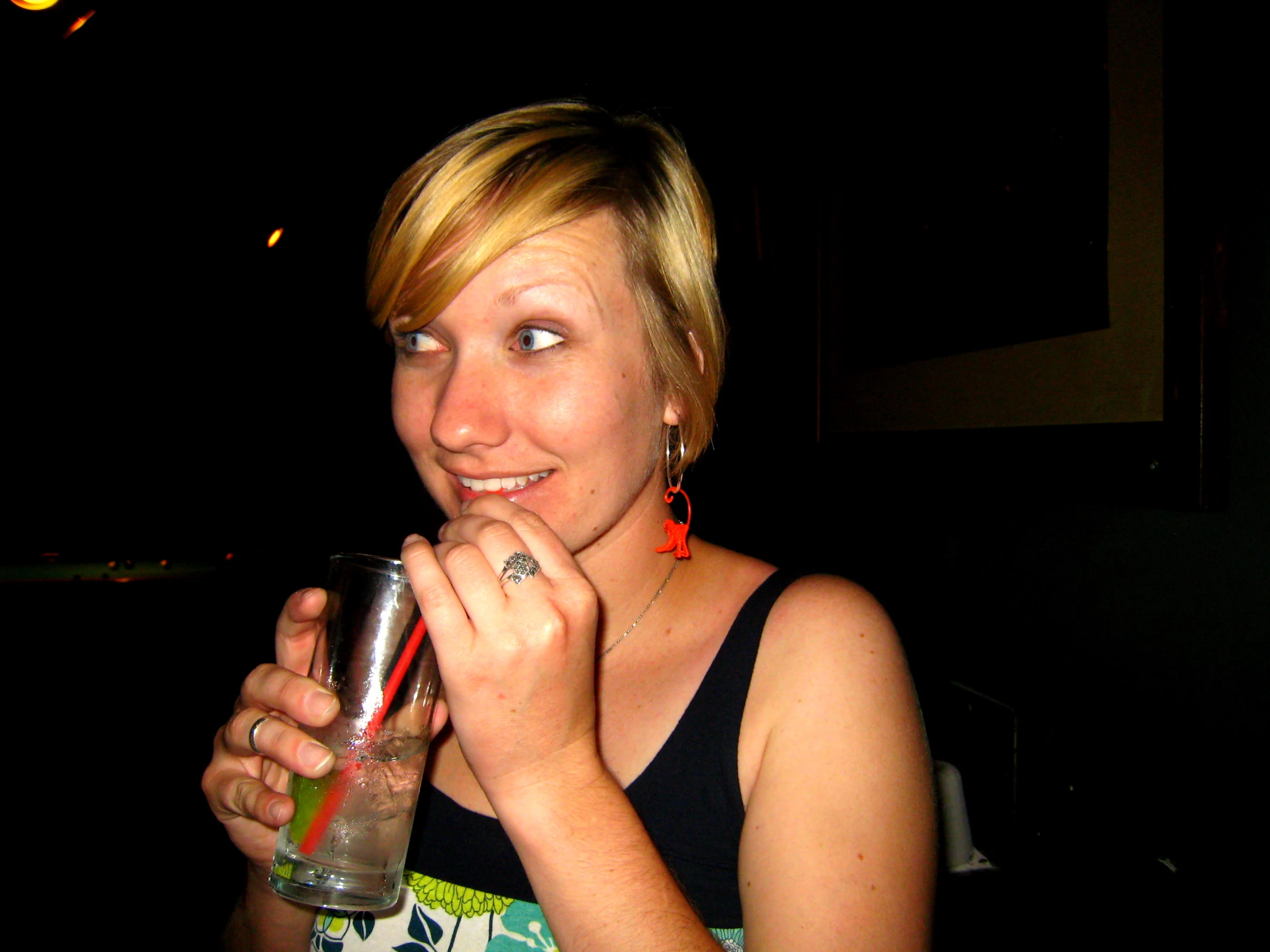 a woman standing in front of a building holding a drink