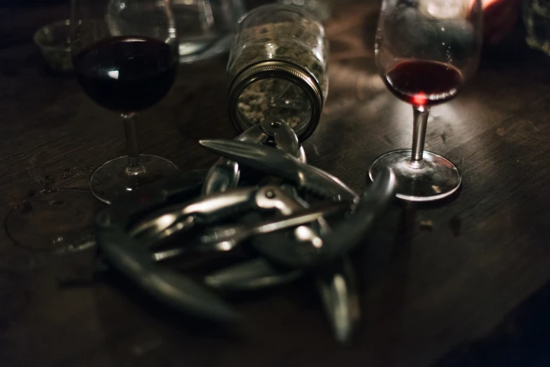 a bottle of wine and several glasses sit on the table