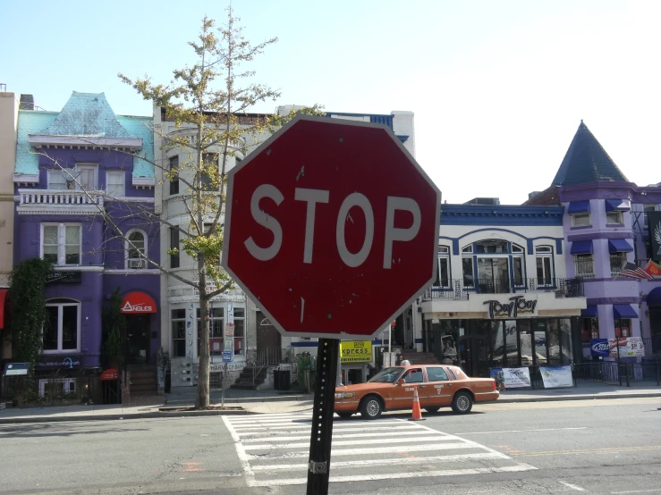 a red stop sign on the corner near a street