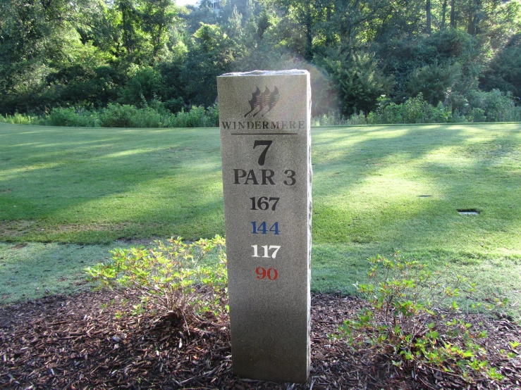 a marker marker in a grassy area next to a park