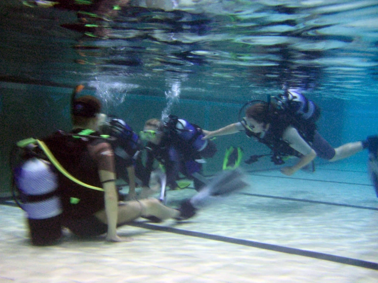 several people scuba in the ocean with many scuba equipment
