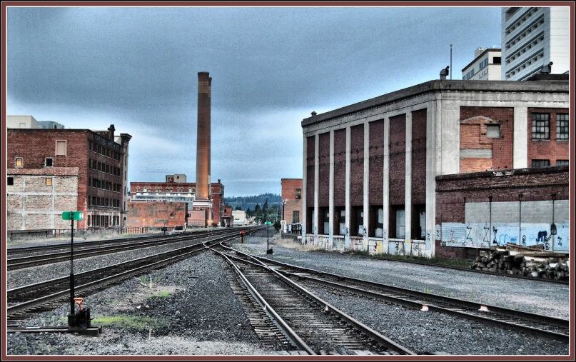 old brick buildings and trains tracks near a train yard