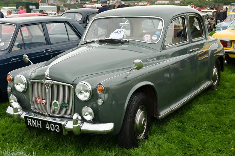 a couple of old cars are sitting in the grass