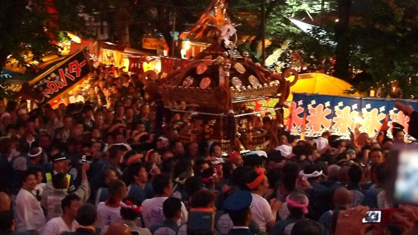 a crowd watching a festival with a float on the side