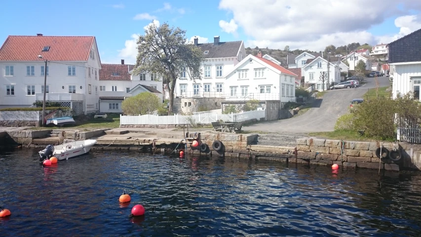 a marina near a row of houses with boats in the water