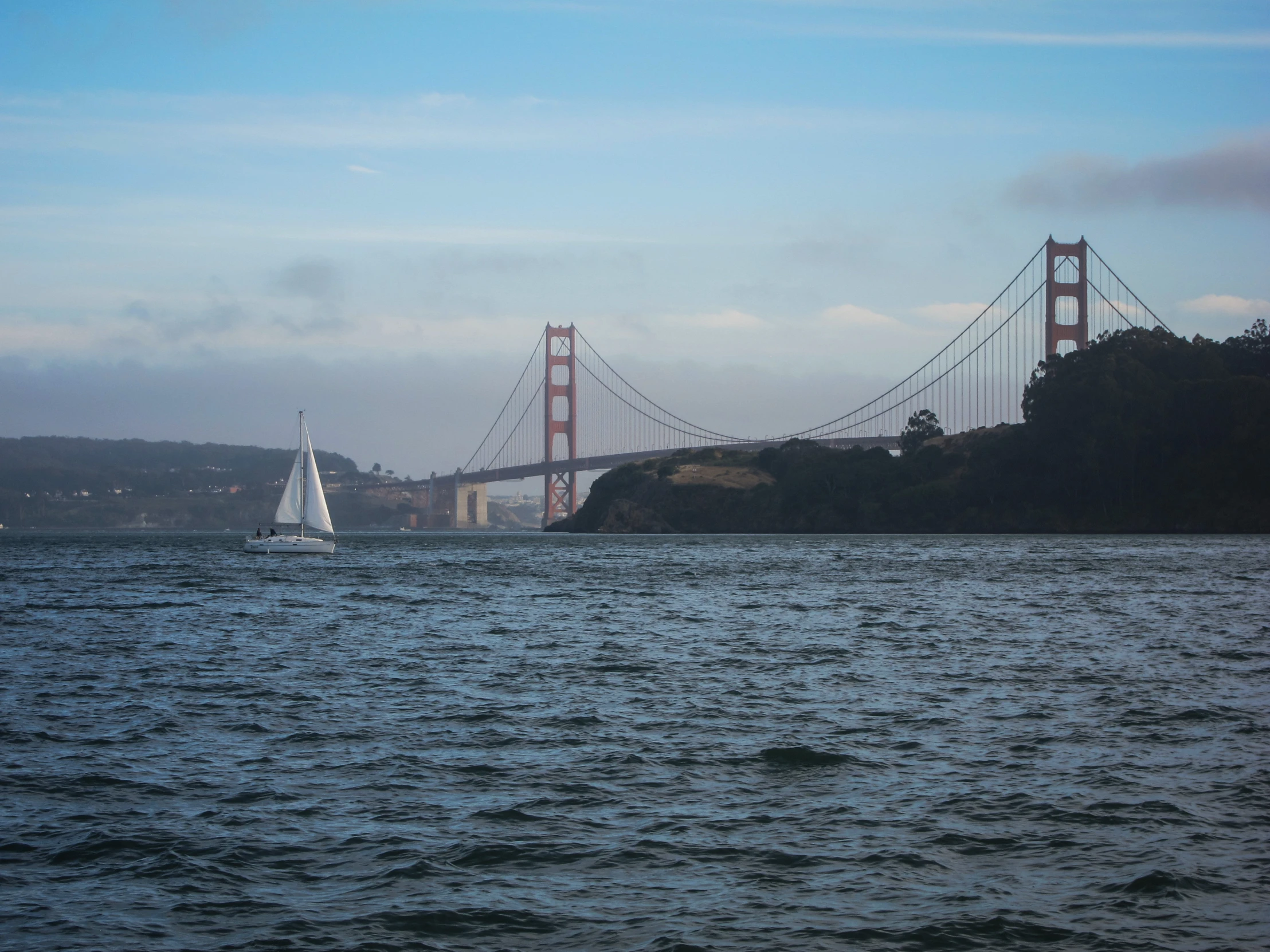 boats sail along the water in front of the golden gate bridge