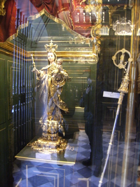 a very large gold statue in a glass case