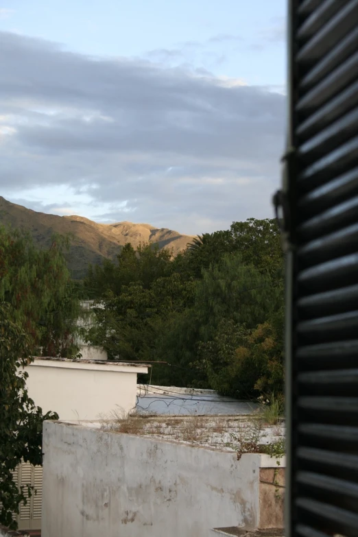 a view of a building and mountains from an outside room