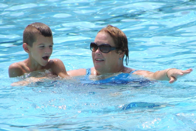 a woman and her son playing in the water