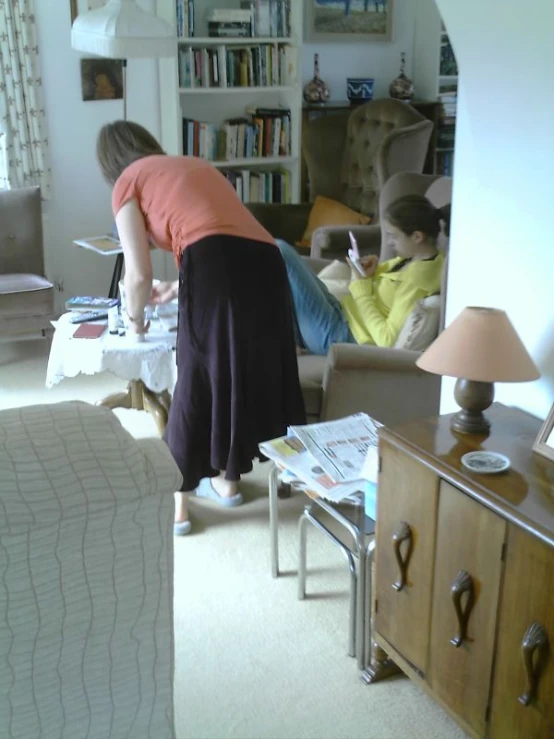 a woman in black pants bends over to check soing out