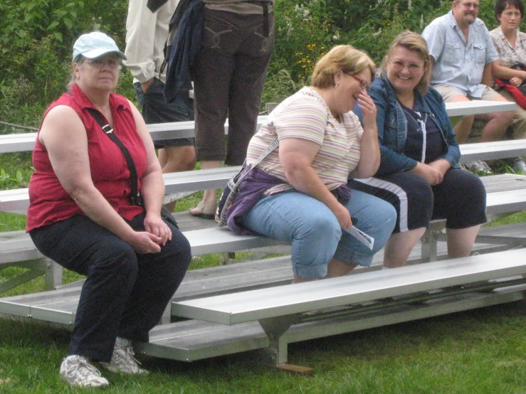 a group of people sitting on top of wooden benches