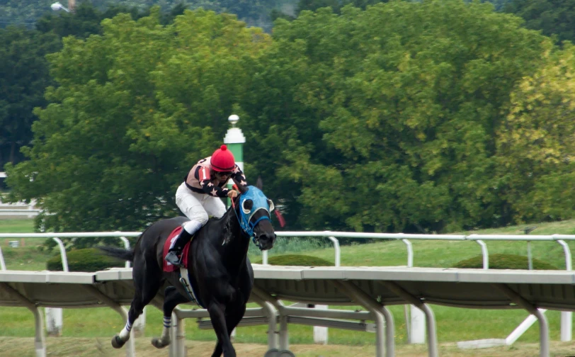 a jockey is riding his black horse in a race