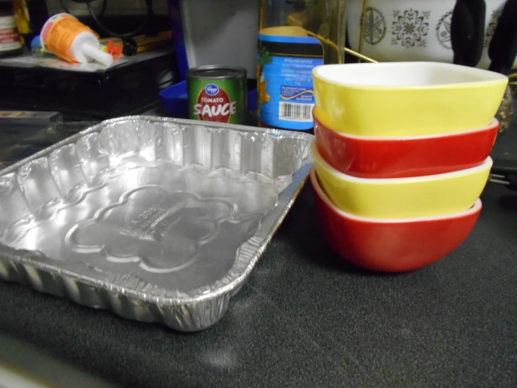 a cake pan next to three bowls and two spoons