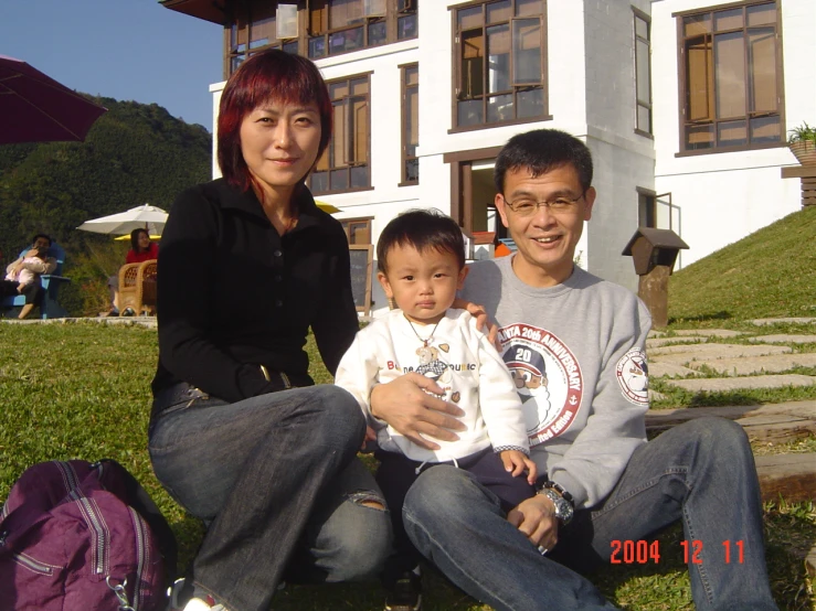 a woman sitting on a bench with a little boy in her lap