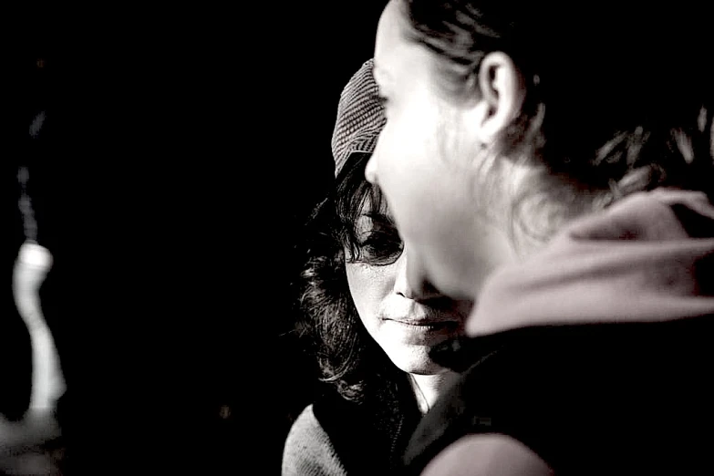 a woman is seen looking down while she has her face illuminated