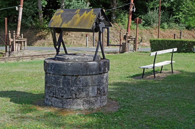 a statue in the middle of the park near a bench