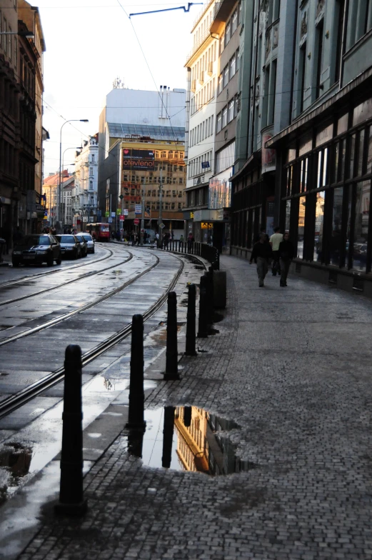 a wet city street that's reflecting its reflection